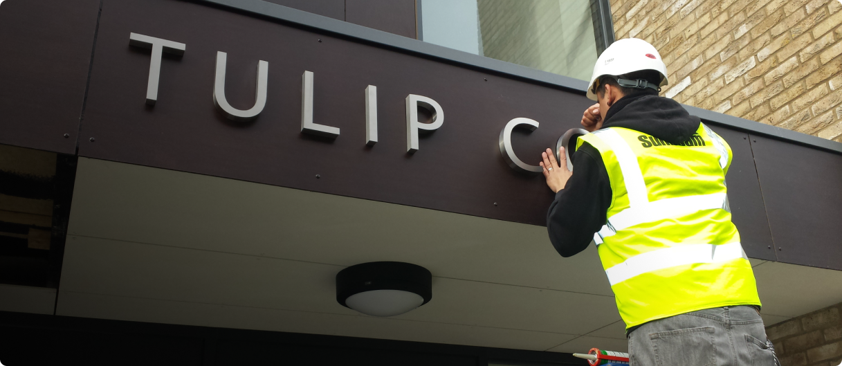 man in construction vest installs sign